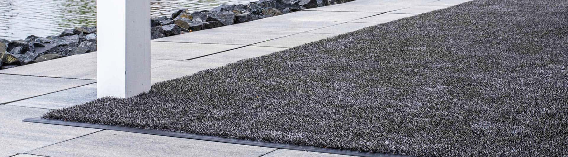 Antraciet kunstgras tapijt op een terras aan het water